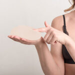 Young woman touch her breast implant